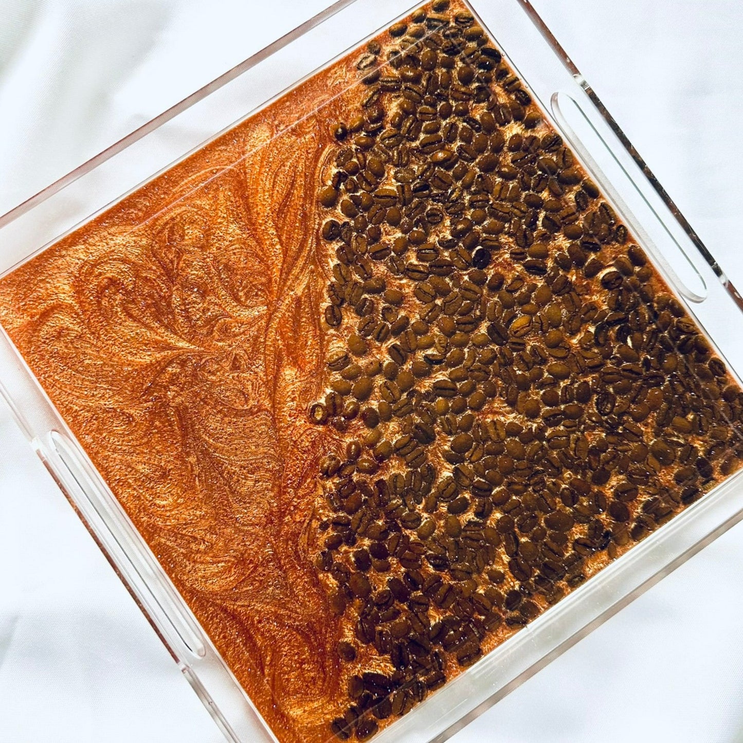 A square acrylic tray with a layer of clear epoxy resin and real coffee beans, coffee-colored resin, and a textured design.