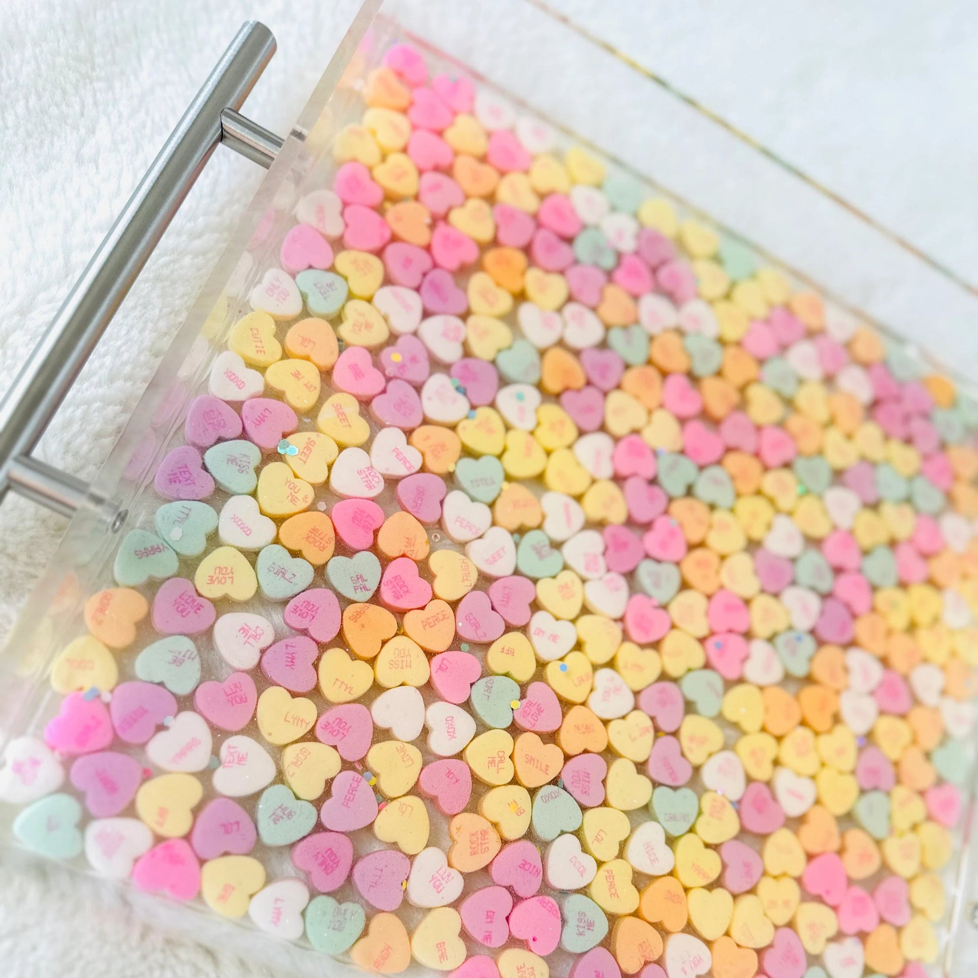 Clear acrylic serving tray with silver handles and filled with colorful conversation candy hearts, sealed in epoxy resin