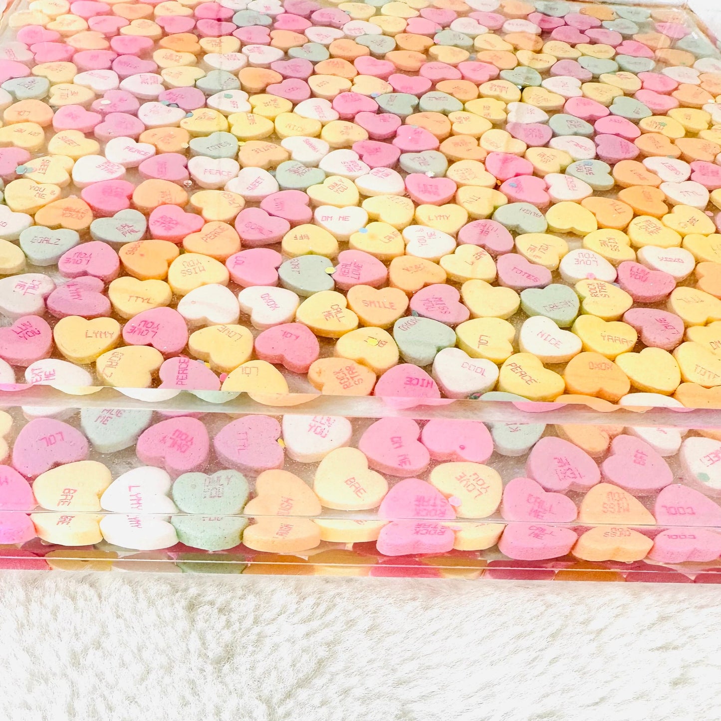 Clear acrylic serving tray with silver handles and filled with colorful conversation candy hearts, sealed in epoxy resin