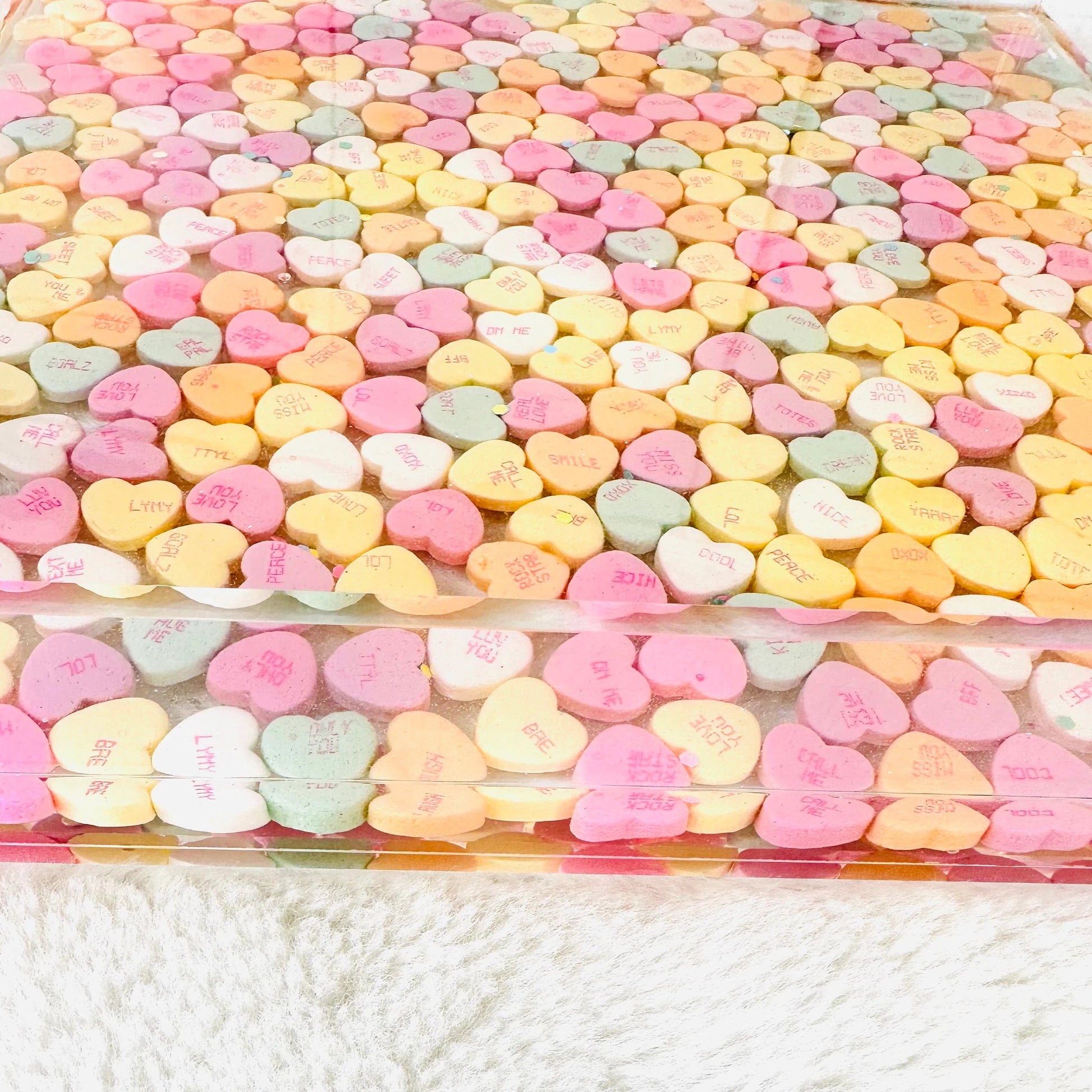 Clear acrylic serving tray with silver handles and filled with colorful conversation candy hearts, sealed in epoxy resin