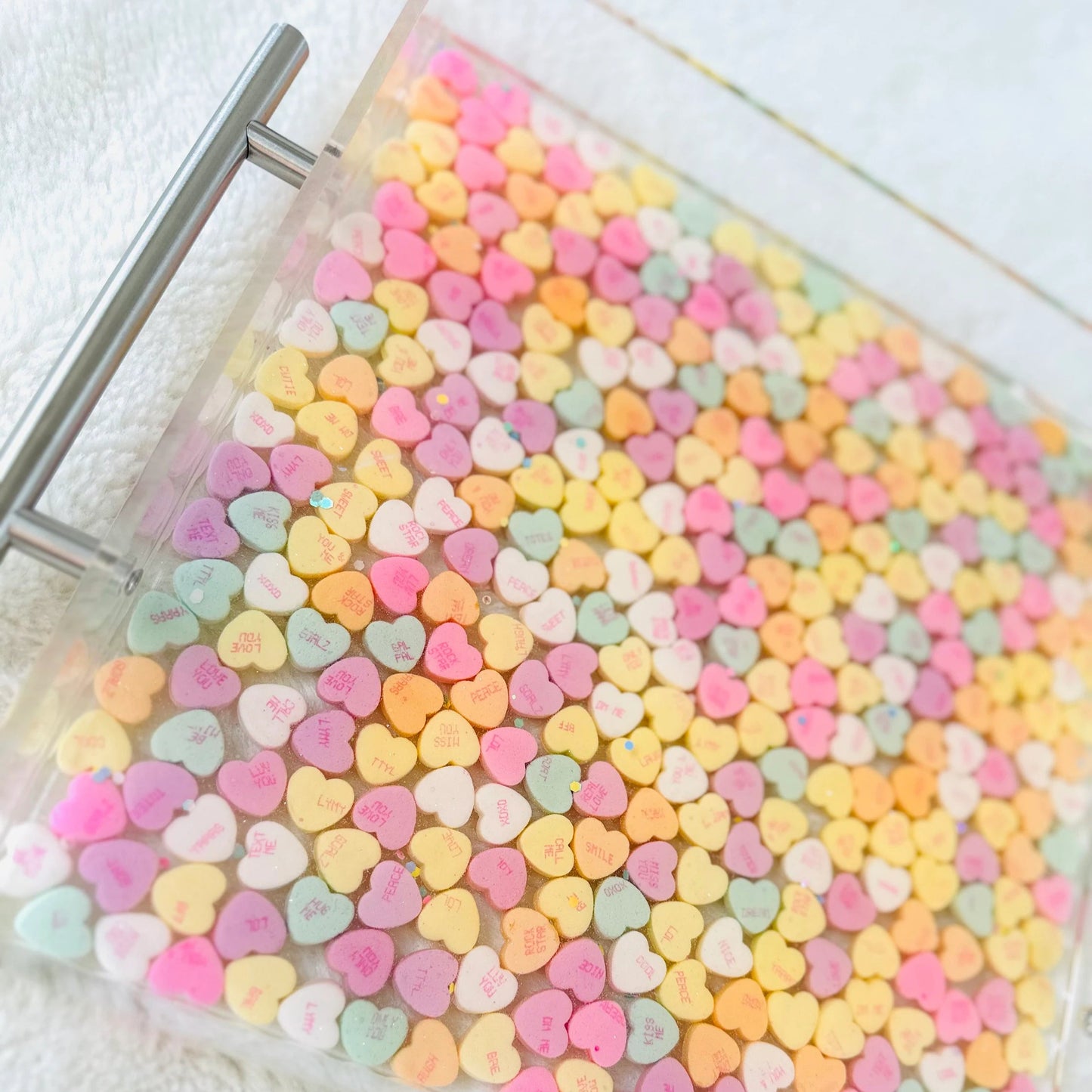 Clear acrylic serving tray with silver handles and filled with colorful conversation candy hearts, sealed in epoxy resin